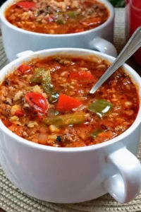 A bowl of hearty stuffed pepper soup garnished with herbs and spices.