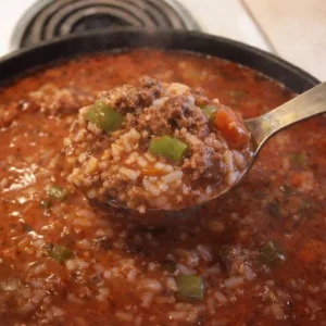 Bowl of stuffed pepper soup garnished with fresh herbs and colorful peppers