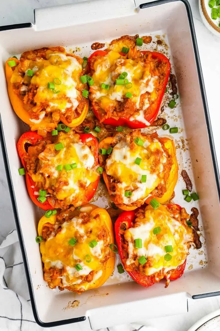 Colorful stuffed peppers filled with rice, beans, and vegetables on a plate.