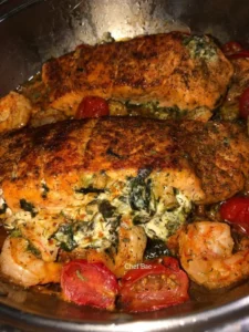 Deliciously prepared stuffed salmon on a plate, garnished with herbs.
