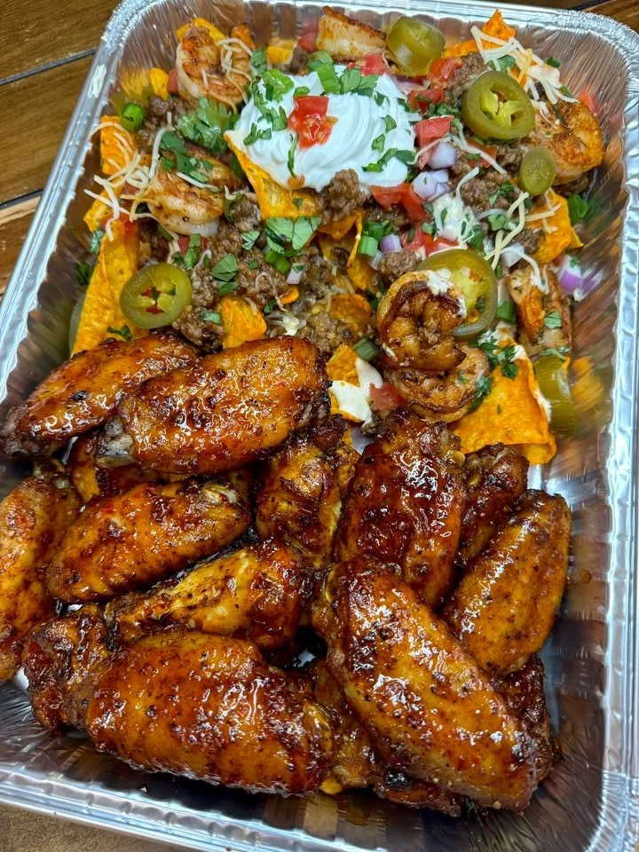 Sweet chili jerk wings served with loaded nachos featuring beef and shrimp.