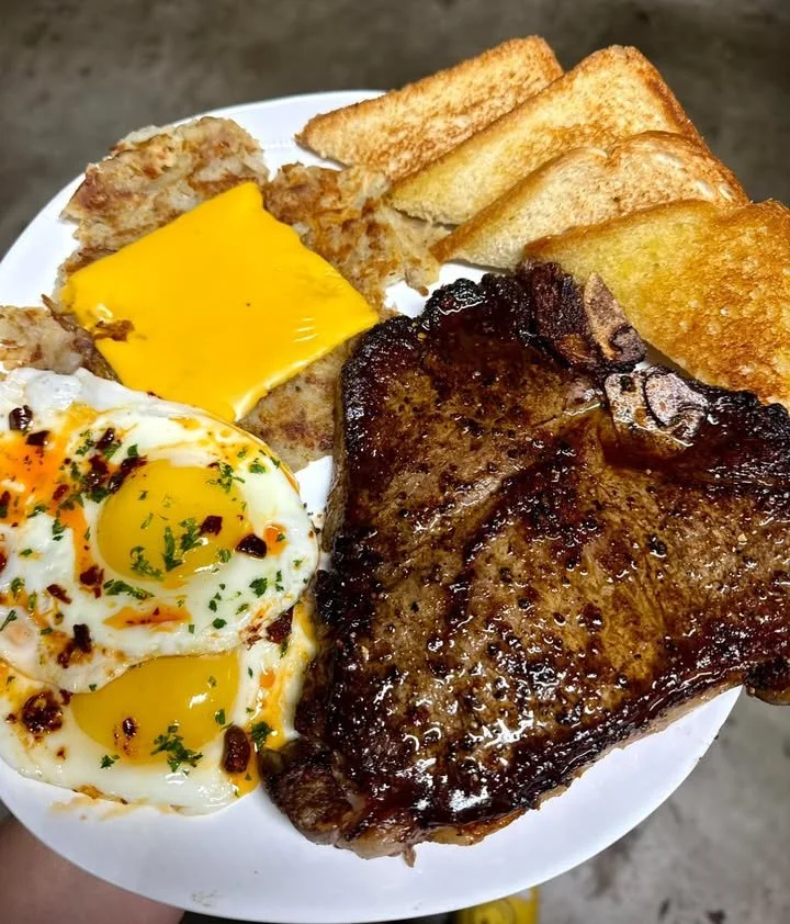 Delicious T-bone steak plated with hashbrowns, eggs, and toast