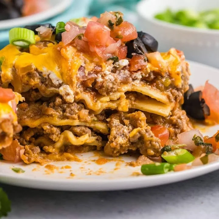 A delicious serving of taco lasagna layered with ground beef, cheese, and toppings.