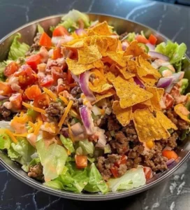 Delicious taco salad topped with fresh ingredients in a bowl.