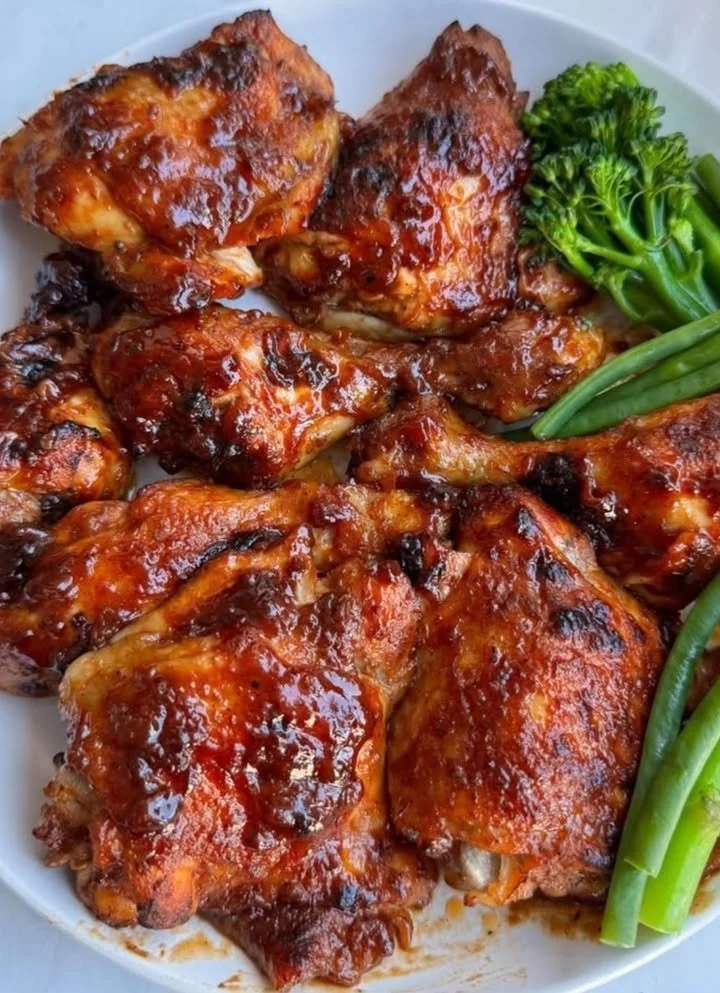 Deliciously grilled BBQ chicken served with sides and garnished with herbs.