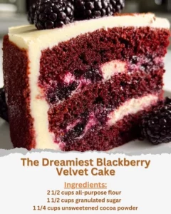 Decadent slice of blackberry velvet cake topped with fresh blackberries