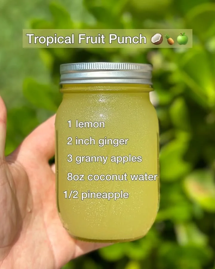 A colorful glass of tropical fruit punch with fresh fruits