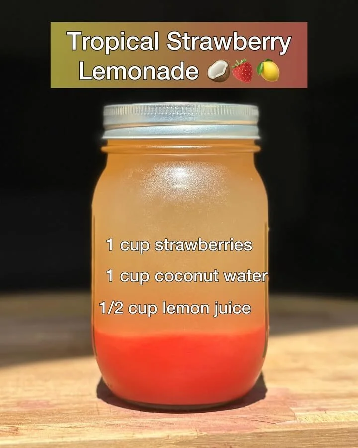 Tropical Strawberry Lemonade served in a glass with ice and fresh strawberries