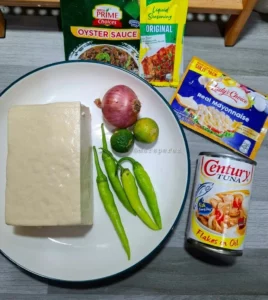 Delicious Tuna Tofu Sisig served on a plate with fresh herbs and spices.