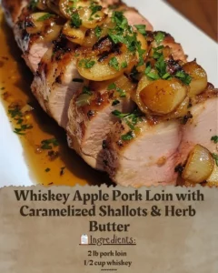 Whiskey Apple Pork Loin with caramelized shallots and herb butter on a serving plate