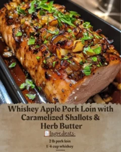 Whiskey Apple Pork Loin garnished with caramelized shallots and herb butter.
