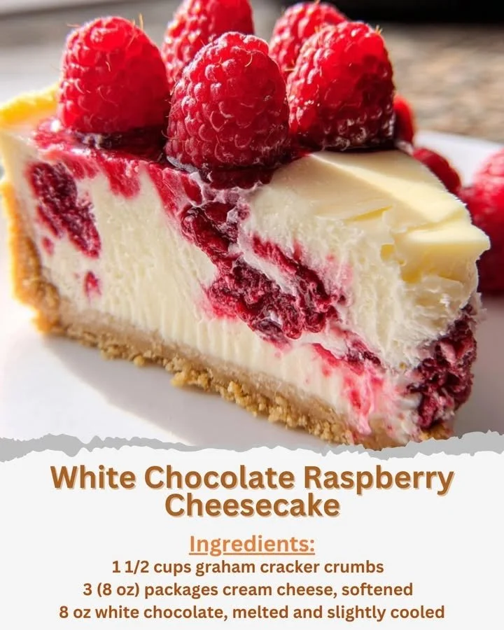 Slice of white chocolate raspberry cheesecake on a plate with fresh raspberries