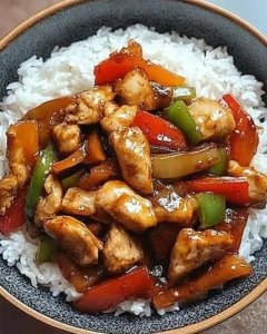 Wok-fried black pepper chicken with aromatic sauce and fluffy rice on a plate