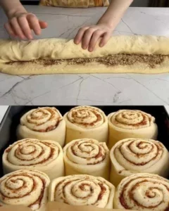 Delicious homemade cinnamon rolls topped with icing on a wooden table.