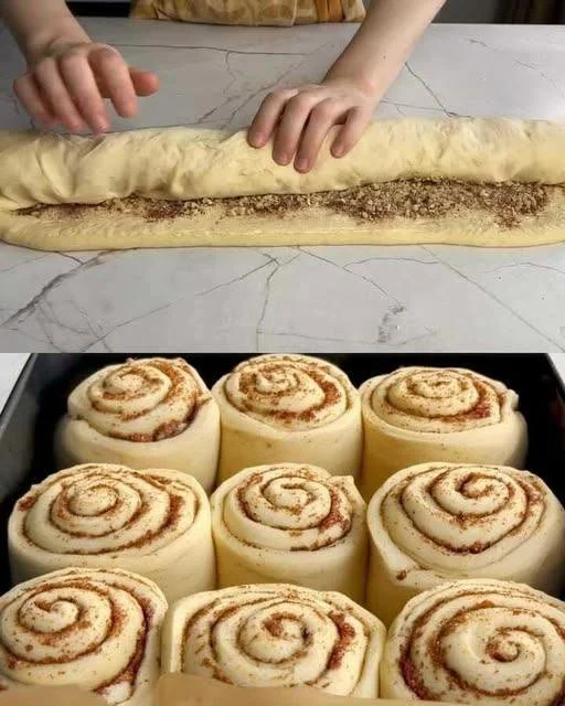Delicious homemade cinnamon rolls topped with icing on a wooden table.