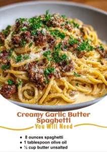 Creamy garlic butter spaghetti garnished with herbs and cheese on a plate.