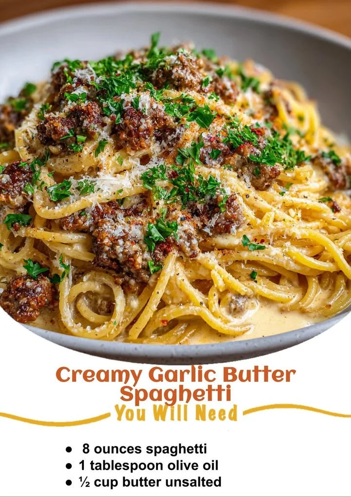 Creamy garlic butter spaghetti garnished with herbs and cheese on a plate.
